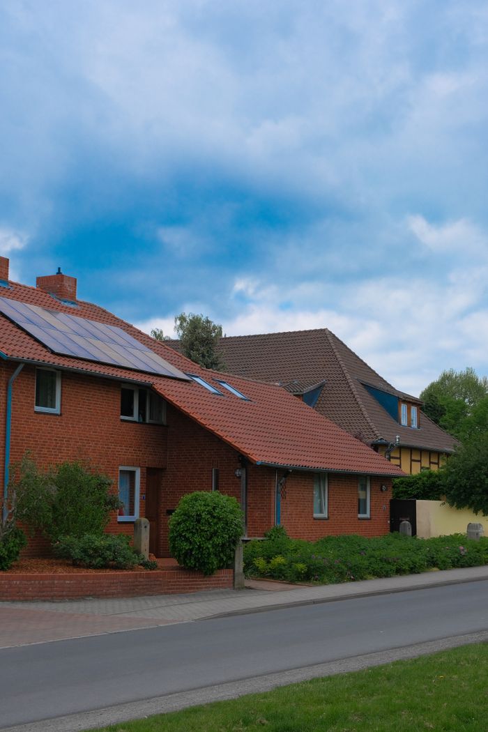 The Art of Drawing Readers In: Your attractive post title goes here Traditional brick houses in Hannover, Germany, featuring solar panels under a blue sky.